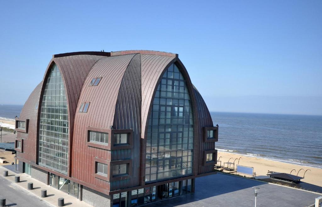 a building on the beach next to the ocean at Poort Beach Boutique Apartments in Bloemendaal Aan Zee