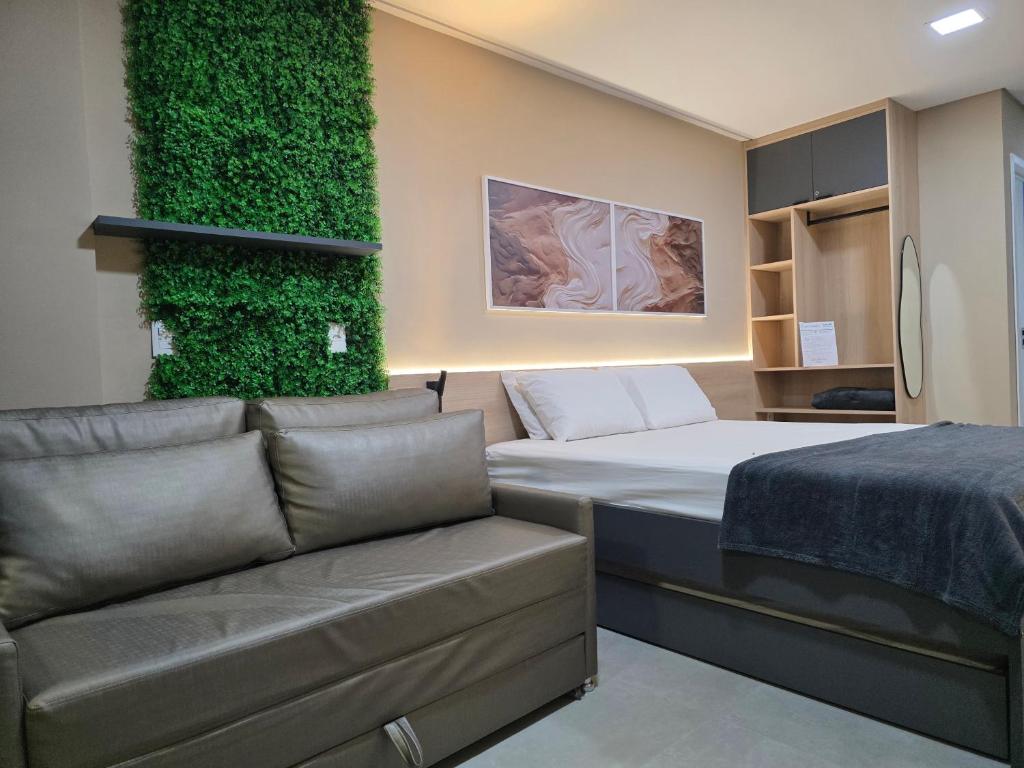 Zimmer mit einem Bett und einem Sofa in der Unterkunft Beach Class Summer Residence em Porto de Galinhas in Porto De Galinhas