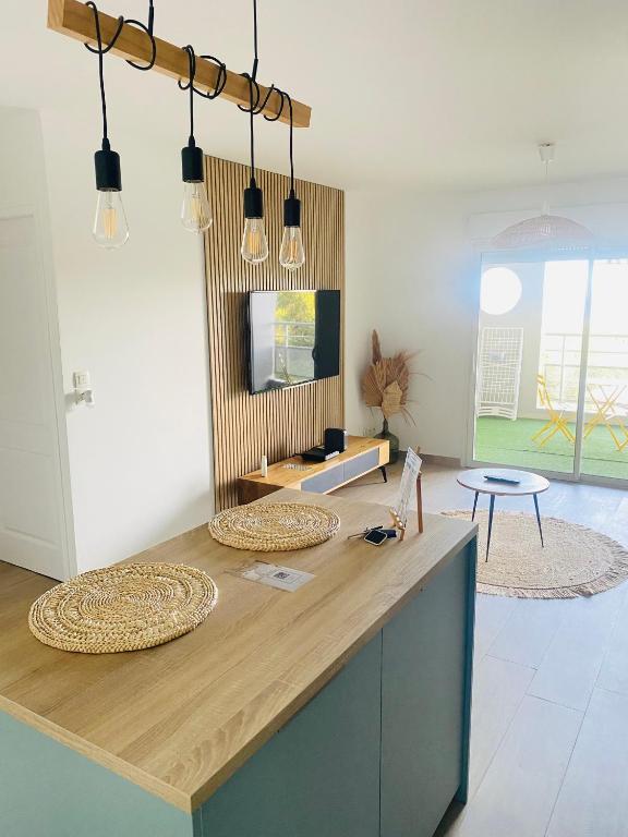 a kitchen with a wooden counter top with lights at Appartement Océan View in Le Robert