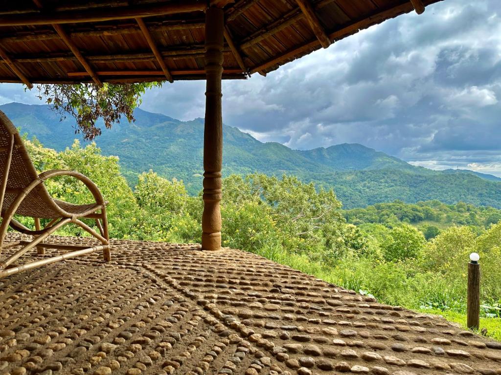 eine Bank auf einer Veranda mit Bergblick in der Unterkunft Pepper Hills Hostel & Cottages in Ella