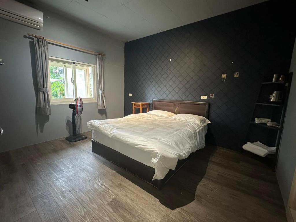 a bedroom with a bed in a room with a window at 輕鬆玩民宿 in Luodong