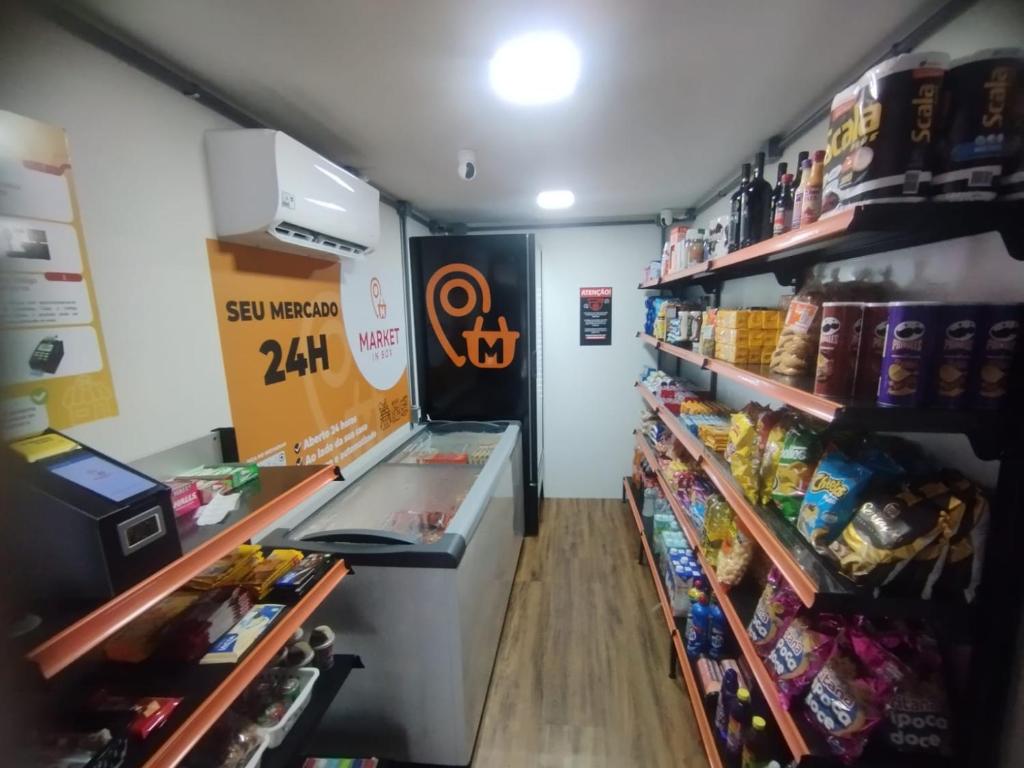 a grocery store aisle with a cash register and food at Studio Completo - Local Central in João Monlevade