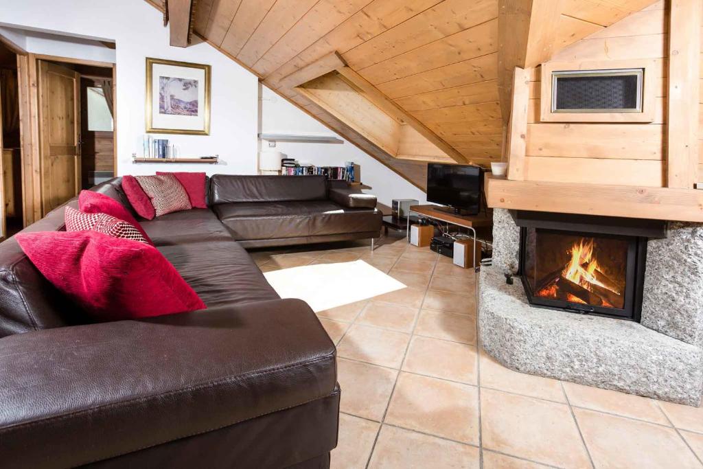 - un salon avec un canapé et une cheminée dans l'établissement Villa Vallet Apartment - Chamonix All Year, à Chamonix-Mont-Blanc