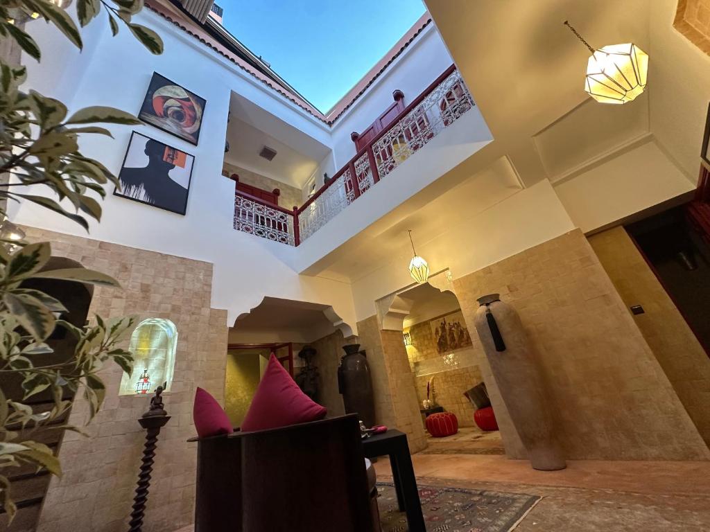 ein Wohnzimmer mit rosa Kissen auf einem Stuhl in der Unterkunft Your Soul's Retreat-Entire Riad in Marrakesch