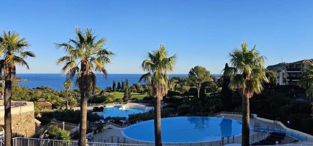 a view of a resort with palm trees at Appartement 4 personnes Cap Estérel centre du village in Saint-Raphaël