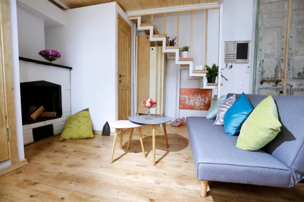 Una sala de estar con un sofá azul y una mesa. en Burbone Apartment, en Turnhout