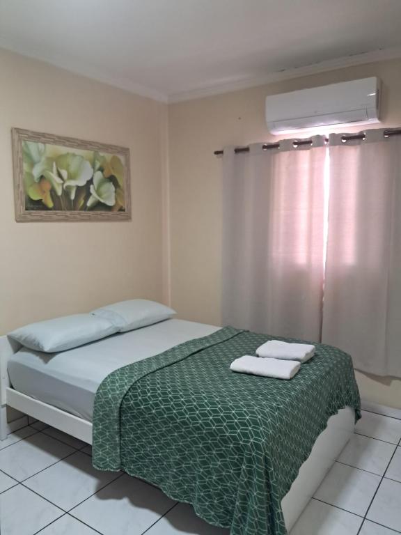 a bedroom with a bed with two towels on it at Casa completa a 10 min do aeroporto Guarulhos in Guarulhos