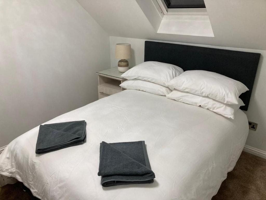 ein Schlafzimmer mit einem weißen Bett mit zwei Kissen darauf in der Unterkunft Luxury townhouse in Stirling in Stirling