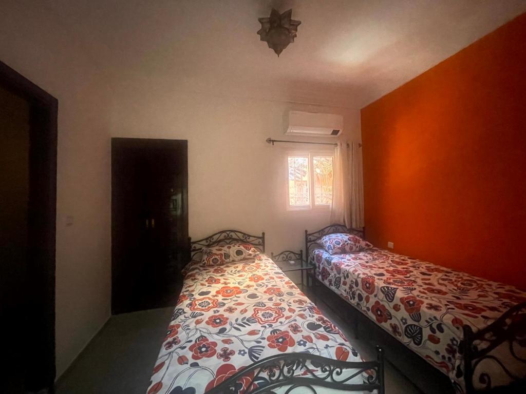 Riad Nora - Confort, Calme & Sécurité في مراكش: غرفة نوم بها سريرين ونافذة