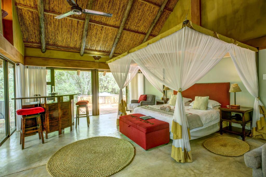 a bedroom with a bed with a canopy at Leopard Walk Lodge in Hluhluwe