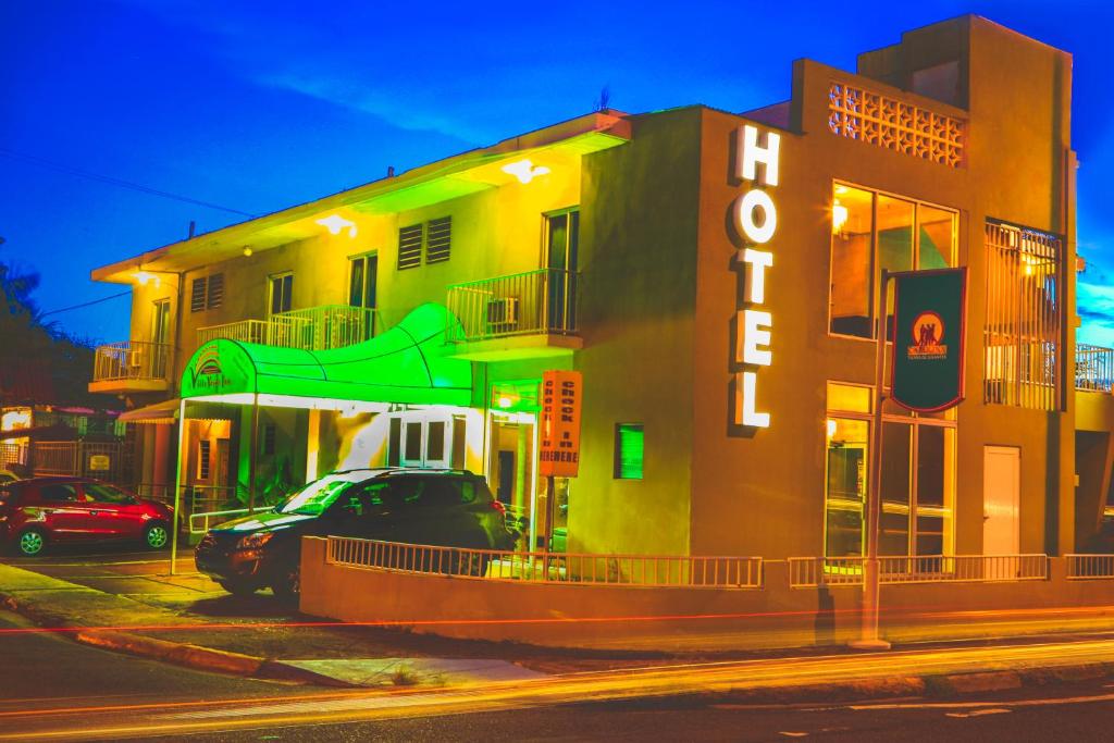 a building with a car parked in front of it at Villa Verde Inn in San Juan