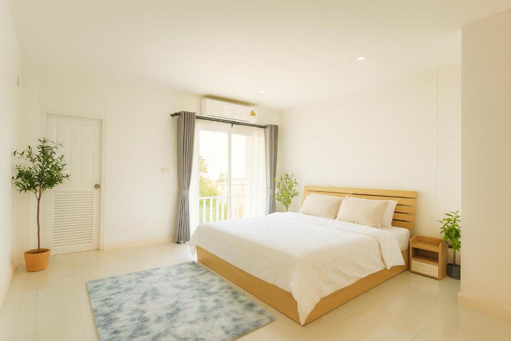 ein weißes Schlafzimmer mit einem großen Bett und einem Fenster in der Unterkunft Dalbit Thai Stay 2 Bedroom Patong house - 8mins walk to Jungcyelon Bangla Rd in Patong Beach