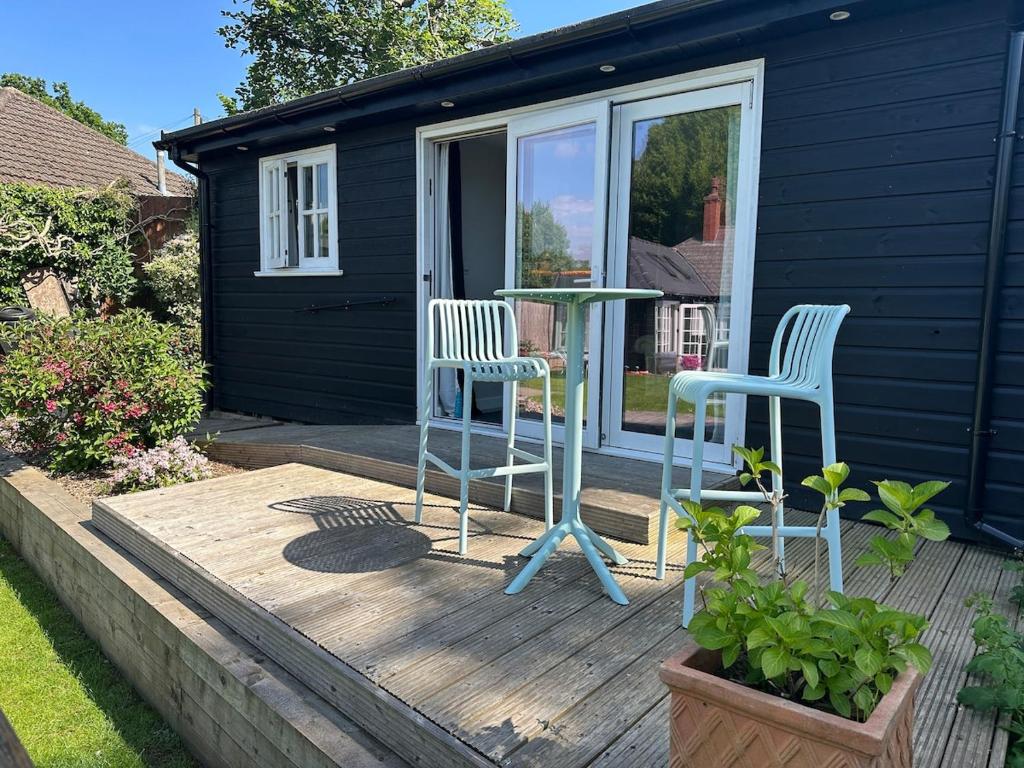 two chairs and a table on a wooden deck at Peaceful Garden Cottage in Birmingham