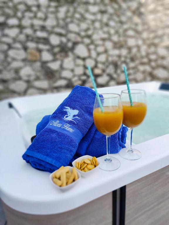 a table with two glasses of orange juice and cookies at Alisea Home in Nerano
