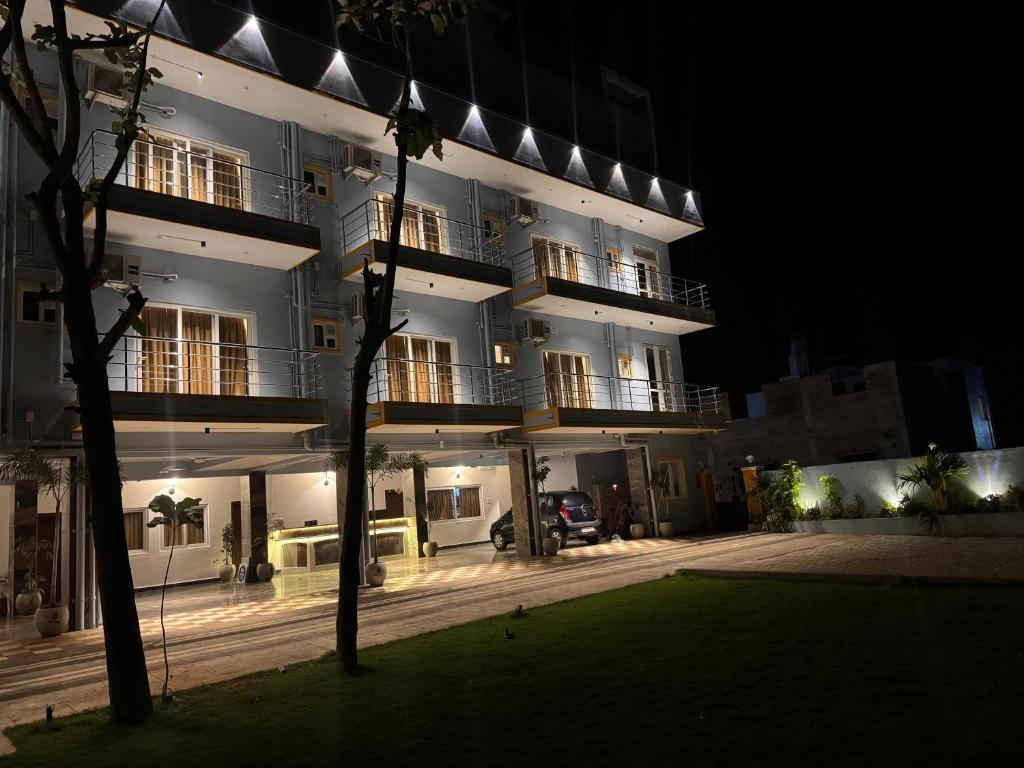 un bâtiment la nuit avec une pelouse devant lui dans l'établissement La Millionaire Resort, à Auroville