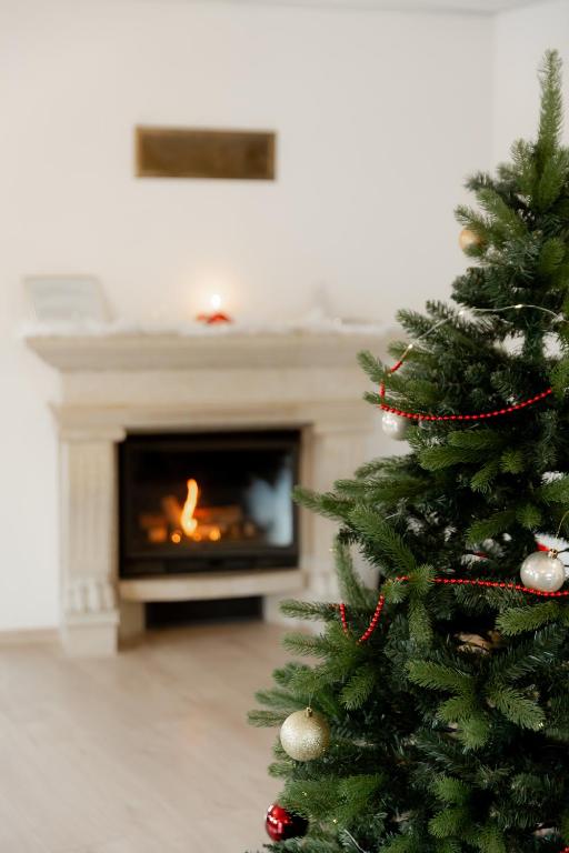 a christmas tree in a living room with a fireplace at Konrad Family Guesthouse in Kuressaare