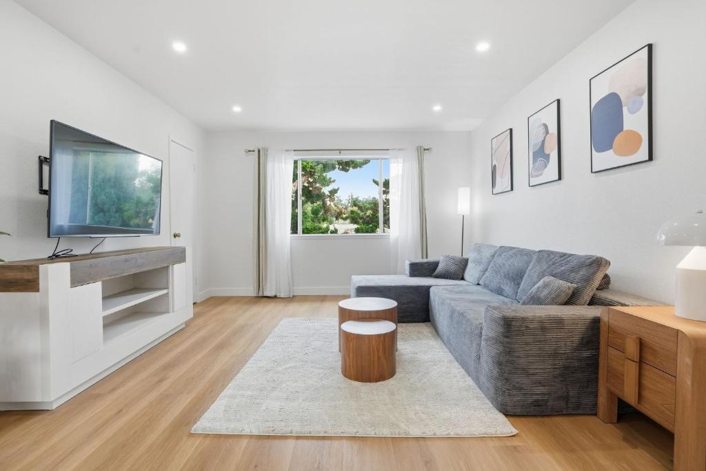 ein Wohnzimmer mit Sofa und Tisch in der Unterkunft Modern 2BR Unit with Covered Parking in Santa Clara apts in Santa Clara