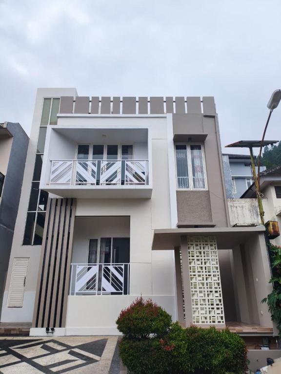 ein weißes Gebäude mit Balkonen an der Seite in der Unterkunft Villa Gamelas Kusuma Pinus Batu in Batu