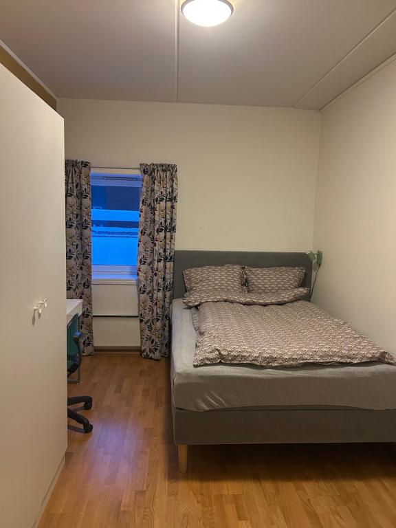 a small bedroom with a bed and a window at City home in Tromsø