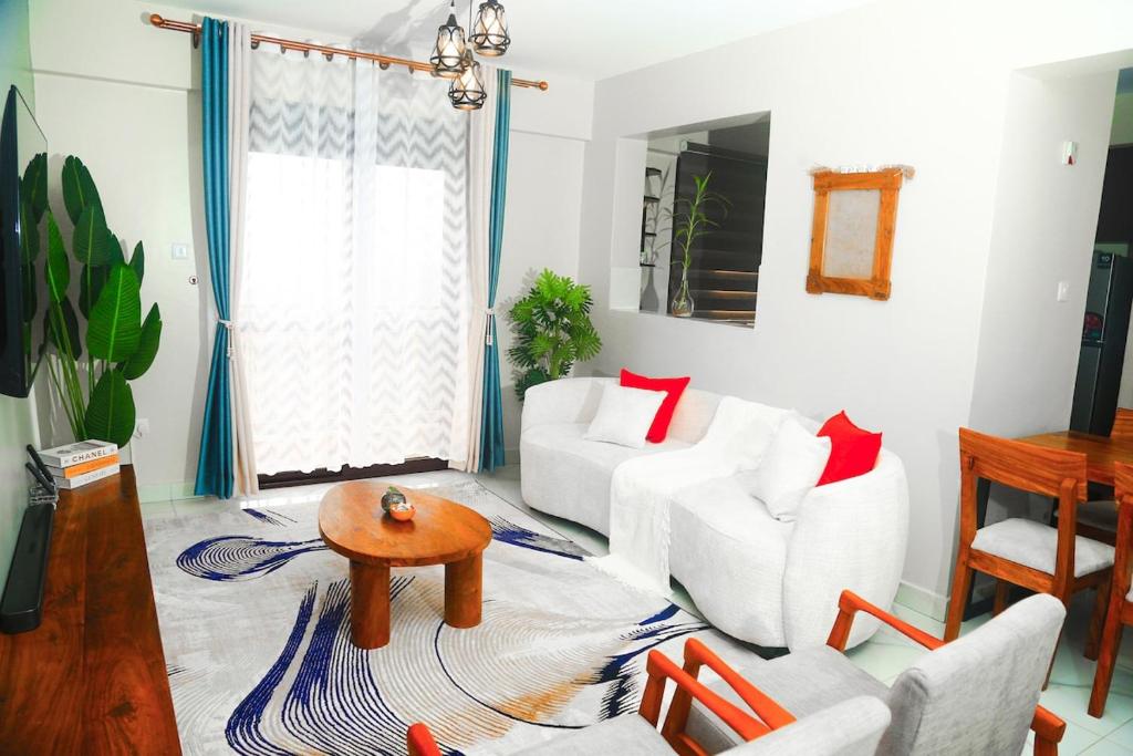 a living room with white furniture and red pillows at Myra Luxury Homes in Kololo- Your Family Oasis in Kampala