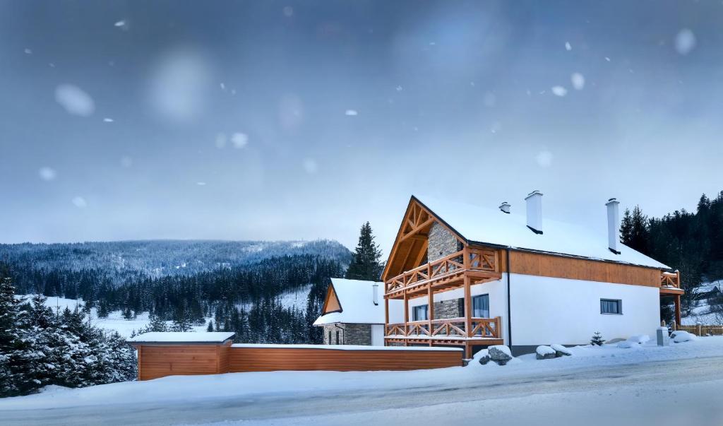 una casa en la nieve con una valla en Chalet Oasis - Luxury Retreat at Chalets Kvačianska Dolina, en Zuberec