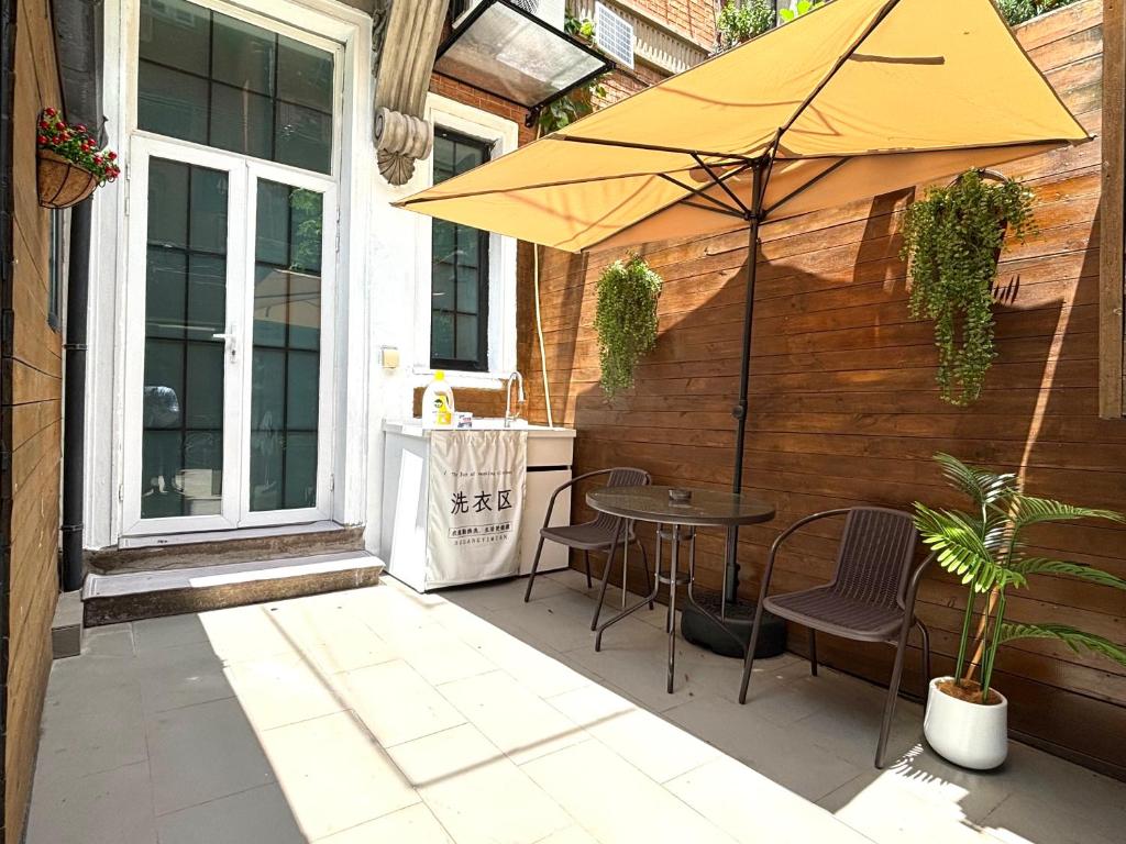 eine Terrasse mit Tisch und Sonnenschirm in der Unterkunft Private Garden Courtyard in Shanghai Old Villa Near City Center Nanjing West Road Metro Station in Shanghai