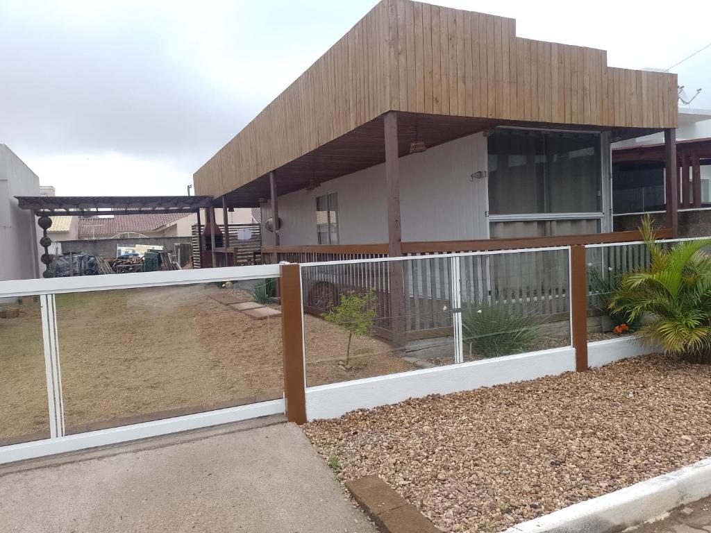 a house with a white fence in front of it at Casa container in São Lourenço do Sul