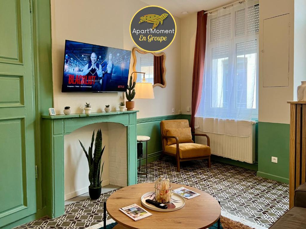 ein Wohnzimmer mit Kamin und Fernseher in der Unterkunft Maison 2 chambres avec bureau - Proche gare in Saint-Omer