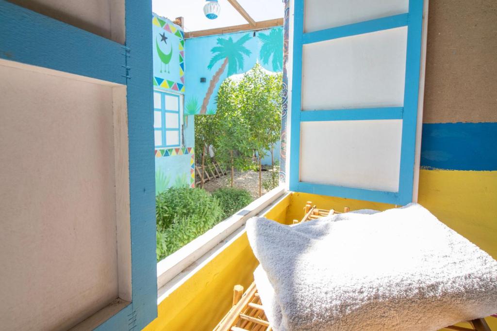 a room with a window with a view of a yard at Pharaohs Rest Luxor in Luxor