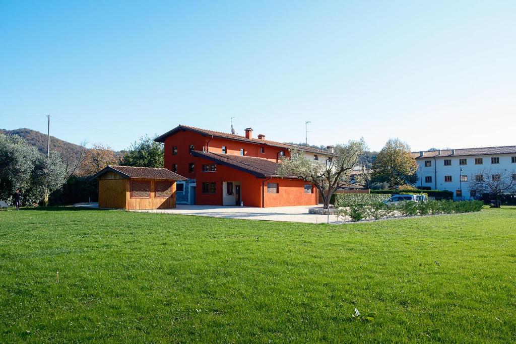 a large red building in a field of grass at Dolcevita guest house in Torreano
