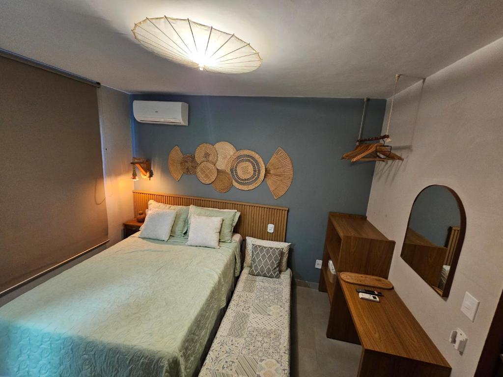 ein kleines Schlafzimmer mit einem Bett und einem Spiegel in der Unterkunft Apartamento Boho Style Absolute piscina borda com borda infinita in Morro de São Paulo