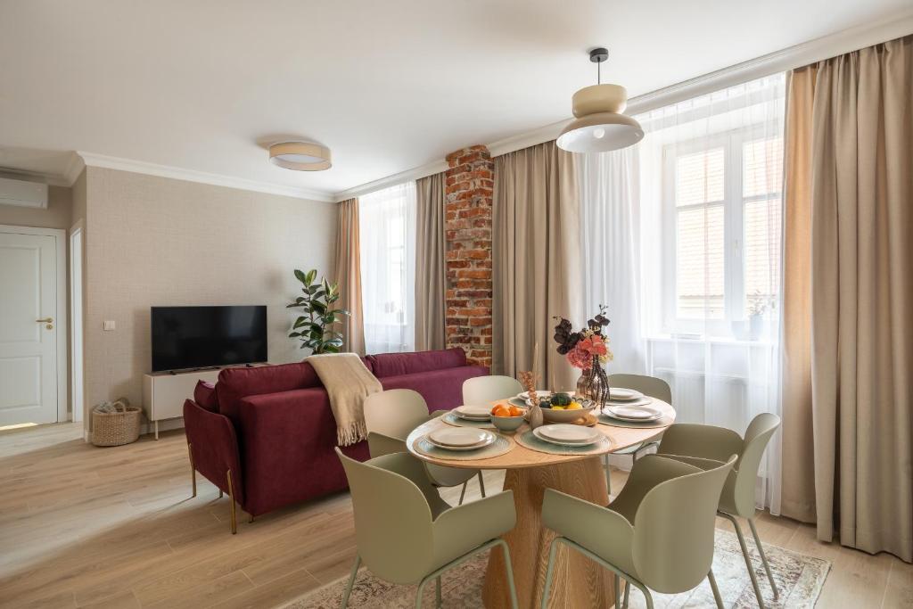 a living room with a table and a red couch at Red Roof Apartments Old Town in Krakow
