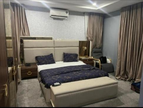 Un dormitorio con una cama grande con sábanas azules. en Suris Hospitality, en Abuja
