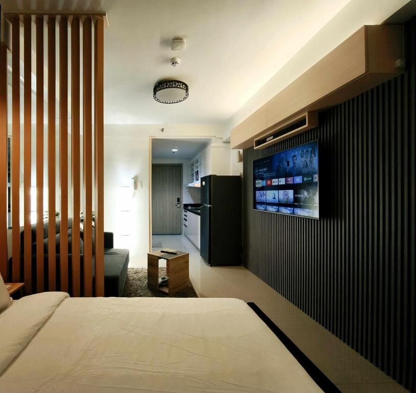 a bedroom with a bed and a television on a wall at Sithonia Suite, Shore Residences Tower C near MOA in Manila