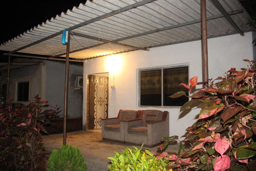 un salon avec un canapé sous une pergola dans l'établissement The Bella Vista Retreat, à Sāsan Gīr