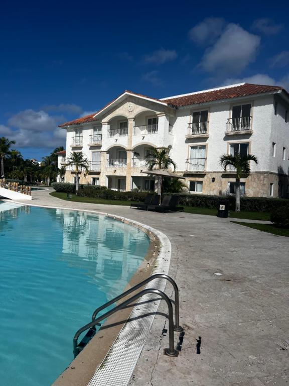 un hotel con piscina frente a un edificio en Cadaques caribe bayahibe, en La Laguna