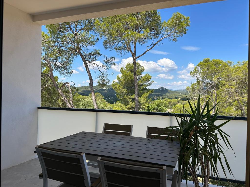 une salle à manger avec une table et une grande fenêtre dans l'établissement Au Pied du Pic Saint Loup, à Saint-Mathieu-de-Tréviers
