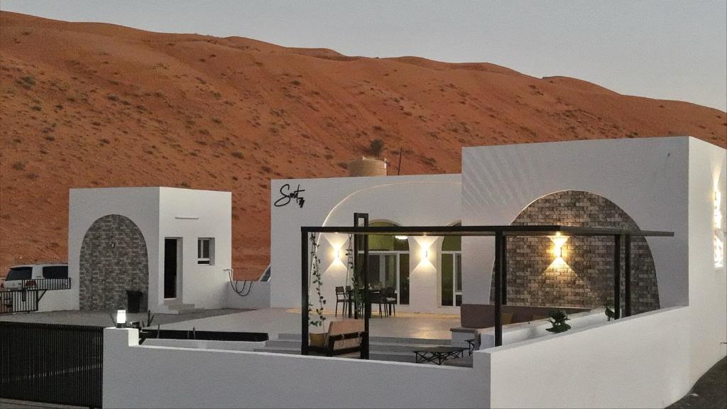 Una casa en el desierto con una montaña detrás. en Sunset77, en Al Wāşil