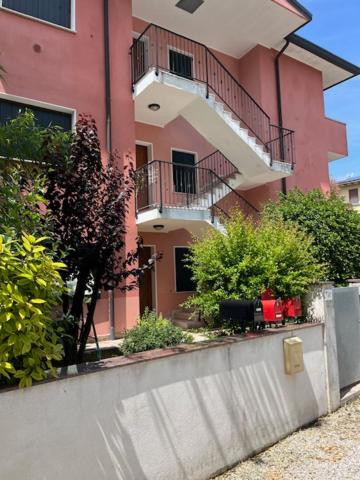 un bâtiment rose avec des balcons et des plantes devant lui dans l'établissement Saffron Suite, just a few minutes from the center and station, à Pordenone