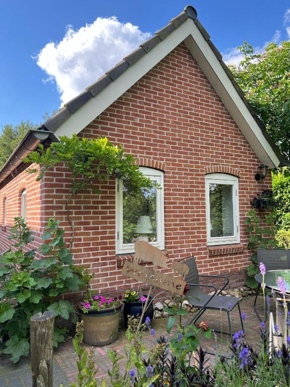 a brick house with a bench in a garden at Diedjestee in Westdorp