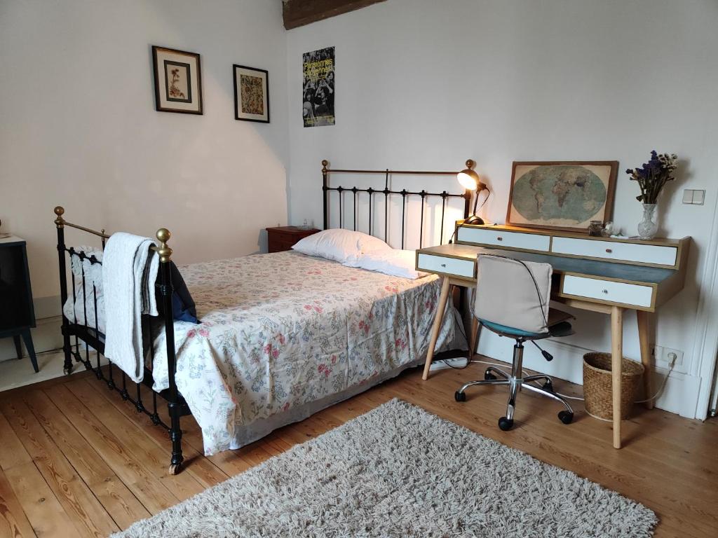 ein Schlafzimmer mit einem Bett und einem Schreibtisch und einem Schreibtisch in der Unterkunft Villa Maria in Condé-Sainte-Libiaire