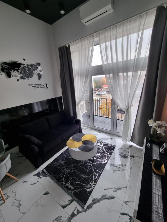 un salon avec un canapé et une table dans l'établissement Apartments by Radecka Zarembowicza Wrocław Lotnisko, à Wrocław