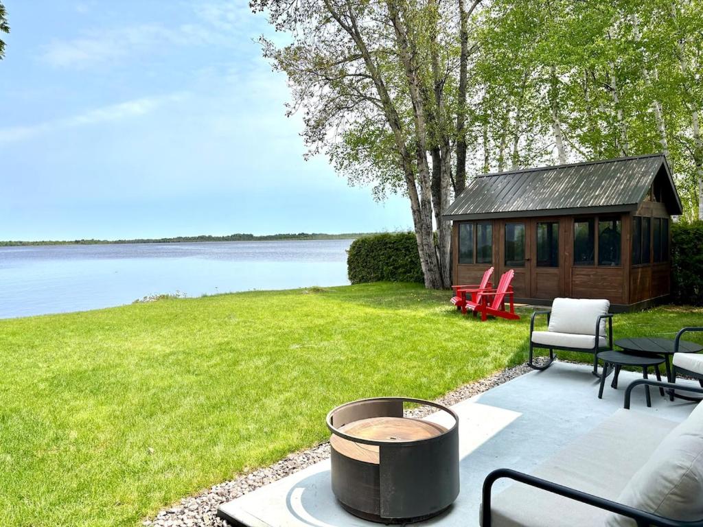 une cour arrière avec une cabane en rondins et un foyer dans l'établissement La maison de la Baie, à Chambord