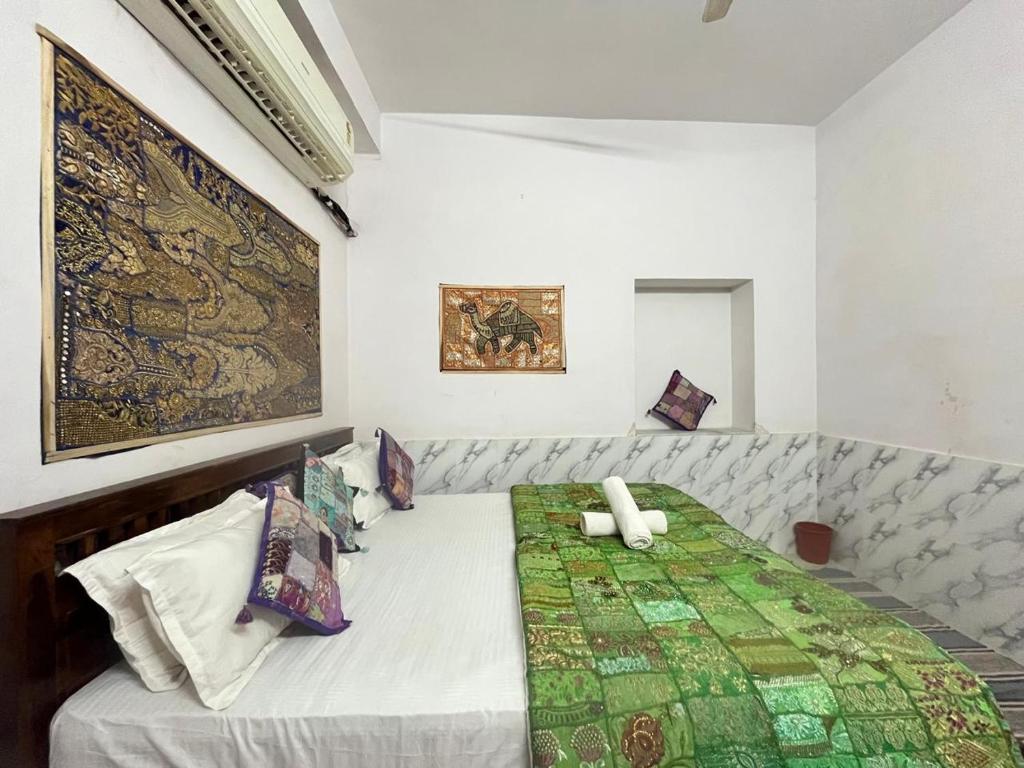 a bedroom with a bed with a green quilt at Hotel haritage desert safari in Jaisalmer