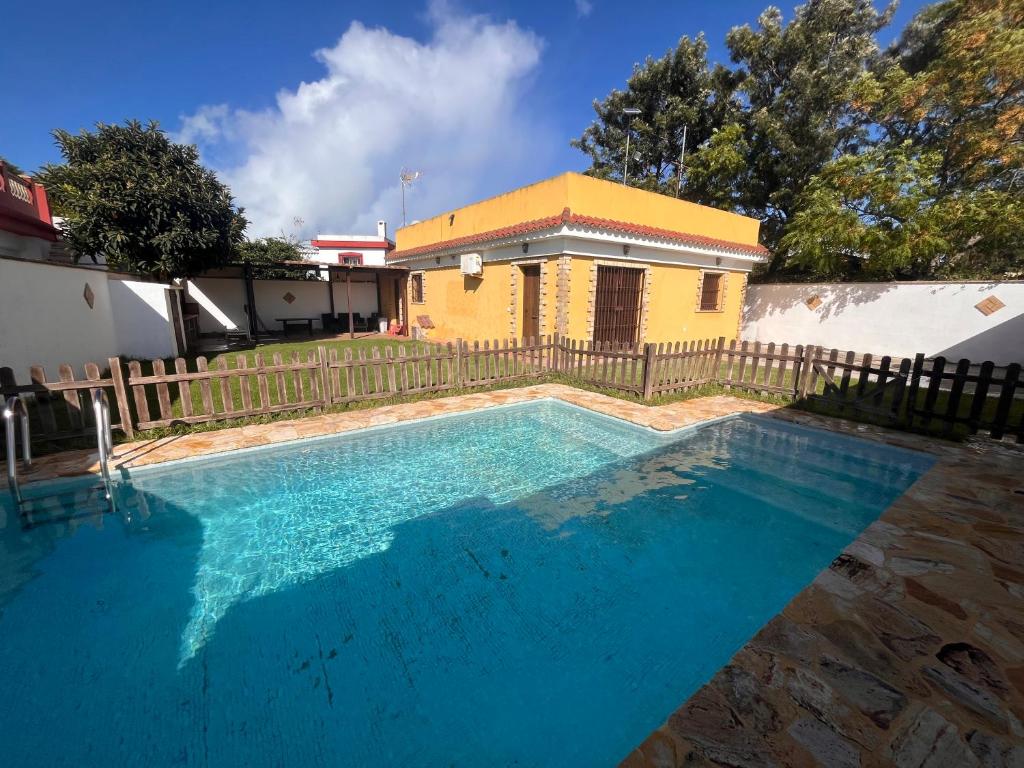 a swimming pool in front of a house at Chalet Playa Paraiso in Cádiz