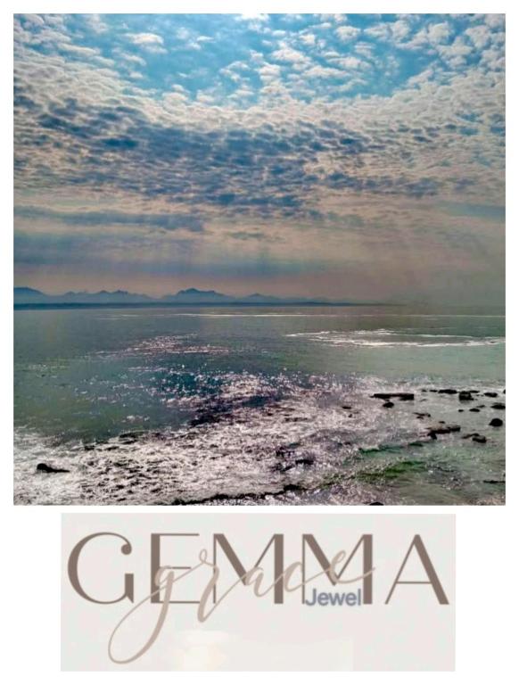 a picture of the ocean with a rainbow in the sky at Gemma in Mossel Bay