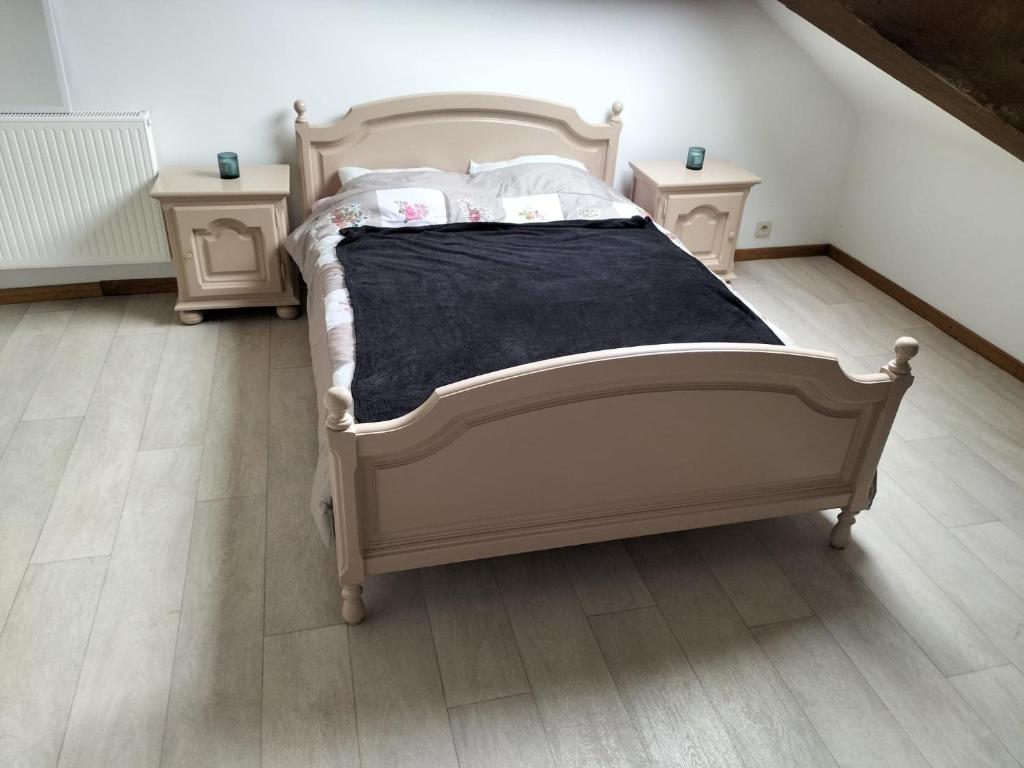 a bedroom with a white bed with two night stands at studio de l'ancienne gendarmerie in Mons