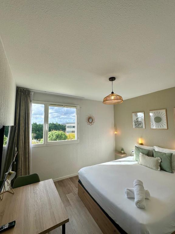 a bedroom with a large white bed and a window at Studio Appart'Hôtel - Avignon gare TGV Confluence in Avignon