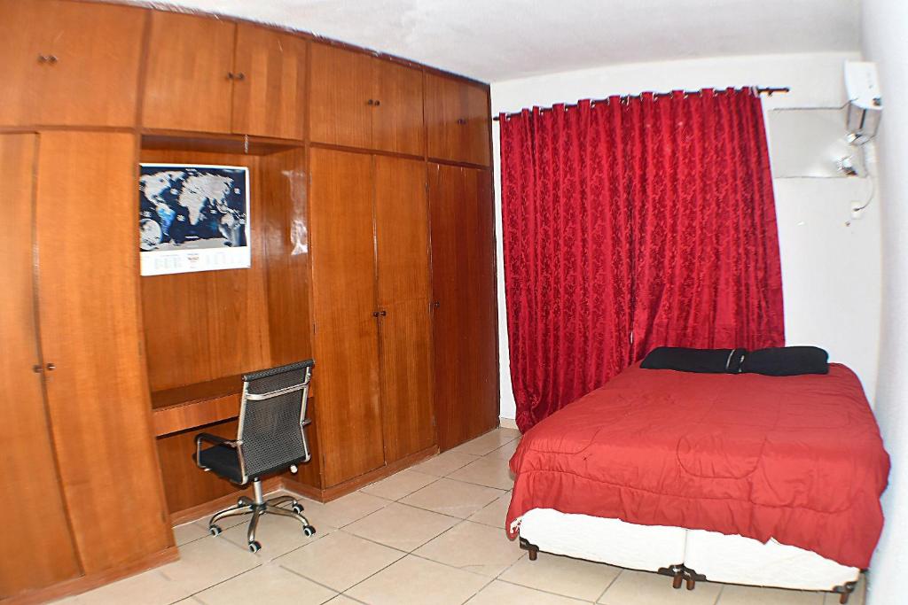 a bedroom with a red bed and a desk at Casa Branca 355 Familiar in Rio de Janeiro