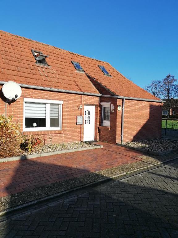 a red brick house with a white door at Piratennest in Osteel
